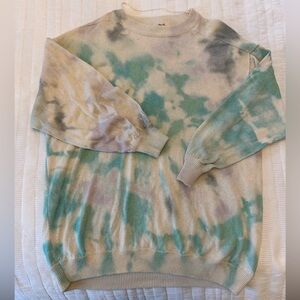 We the Free tie dye sweater. Green and purple on a cream background.